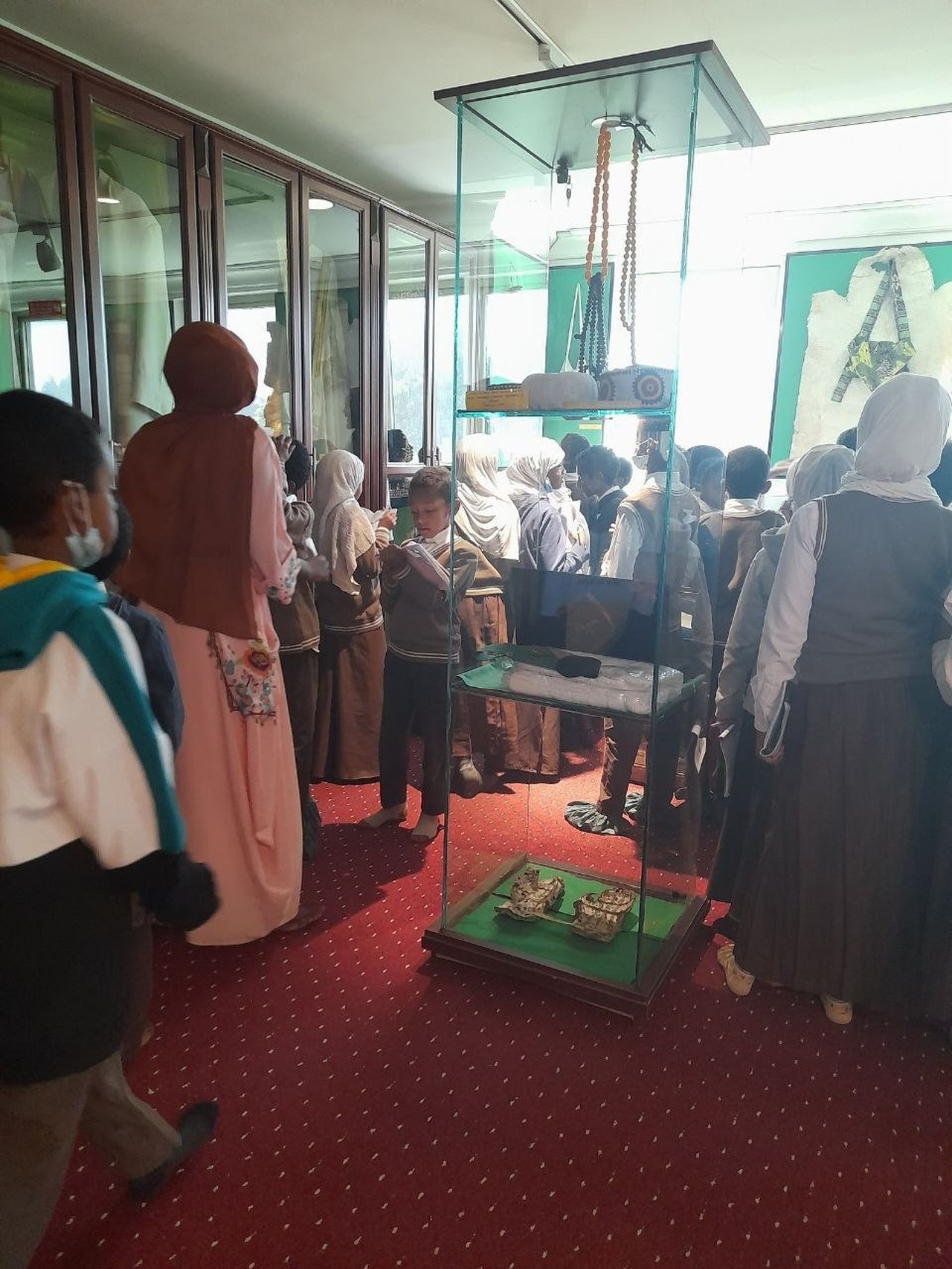 Students observing traditional artifacts and clothing displays at the museum