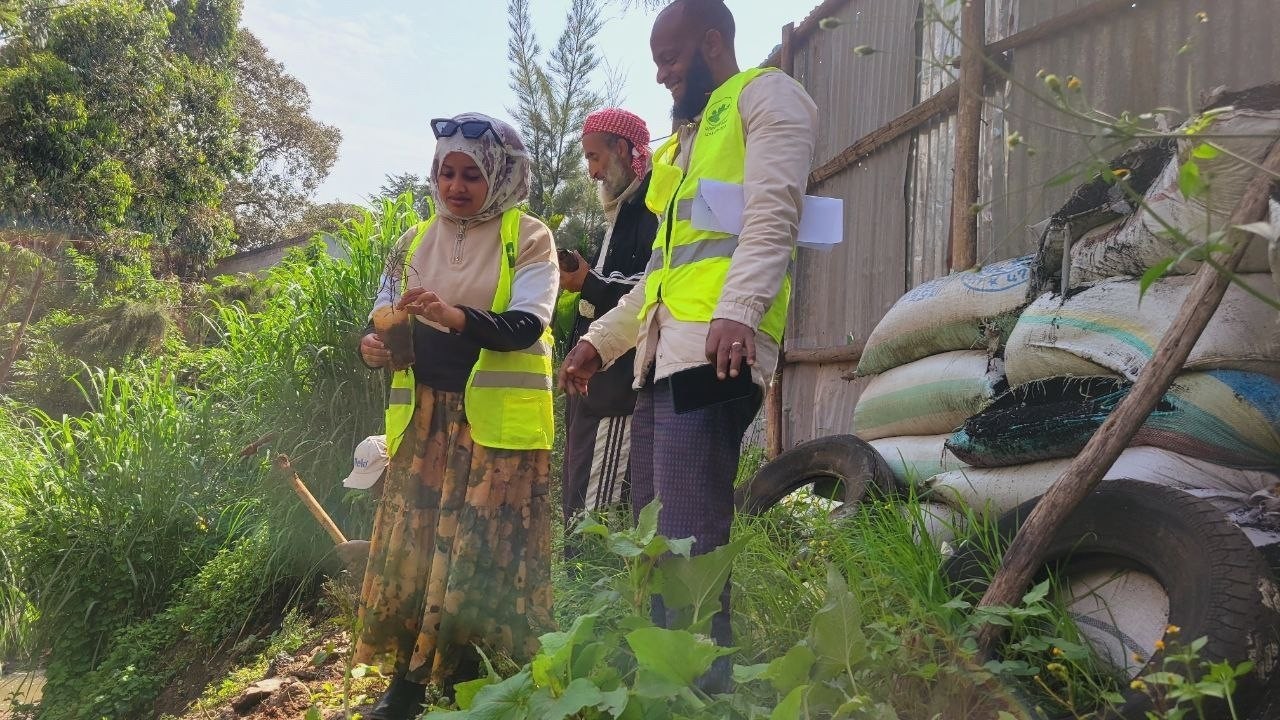 Group of Abadir staff and students holding tree seedlings
